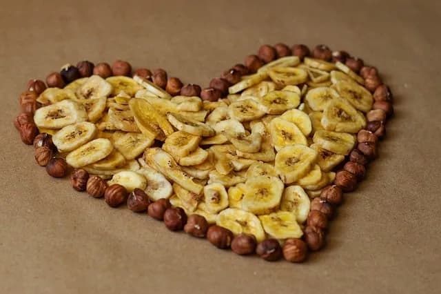 Banana chips and hazelnuts arranged in a heart shape