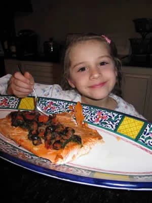 A girl with a plate of salmon and spinach