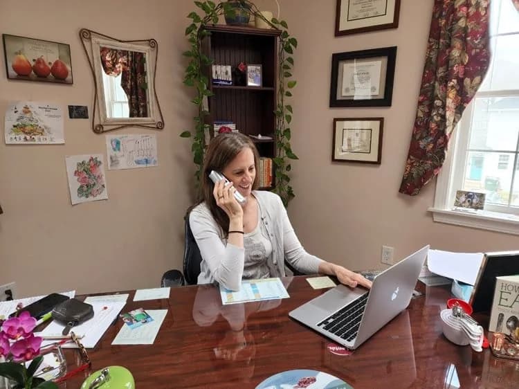 Romely Ritoli on the phone at her desk in the West Hartford office