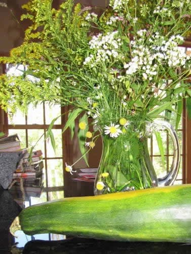 Wildflowers in a glass pitcher on a kitchen counter