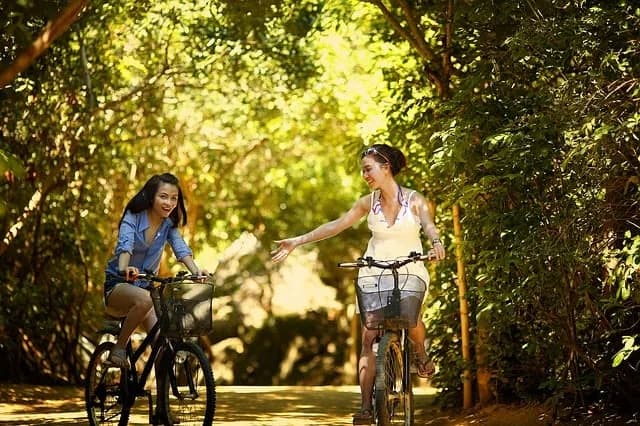 Two women riding bicycles outdoors